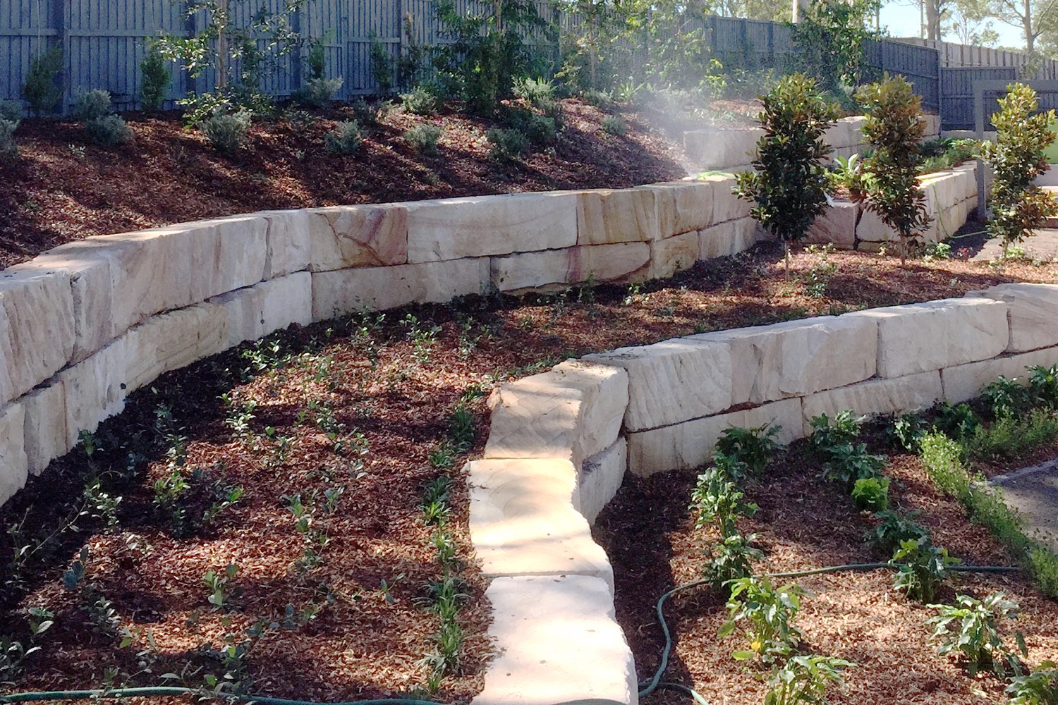 A sandstone log retaining wall built by Novascape Landscaping